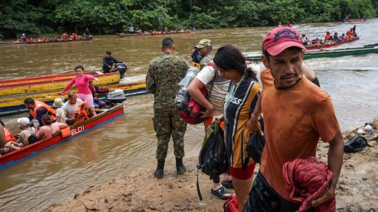 Un militar panameño recibe a un grupo de migrantes que cruza un río en la selva del Darién, el 18 de agosto de 2023. 