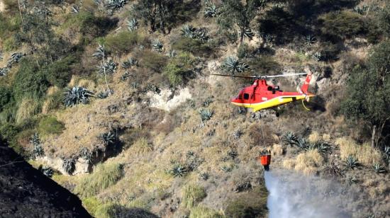 El helicóptero de los Bomberos de Quito arroja agua en Itulcachi.