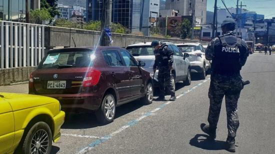 Personal policial revisa los vehículos estacionados en los exteriores del edificio de los medios públicos, el 6 de septiembre de 2023.