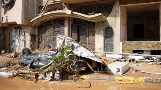 Daños causados por las inundaciones en vehículos y edificios en una calle de Derna, ciudad al este de Libia.