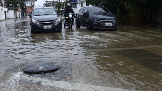 Una alcantarilla se rebosa en una calle de Urdesa, al norte de Guayaquil, tras una lluvia el 23 de marzo del 2023.