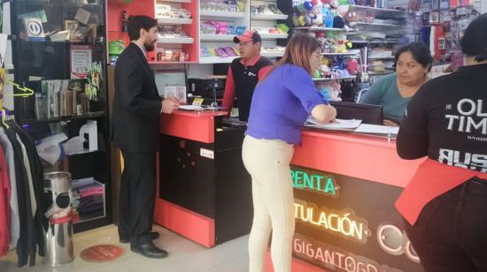 Dos trabajadores atienden a sus clientes en un almacén de Guayaquil, el 5 de julio de 2023.