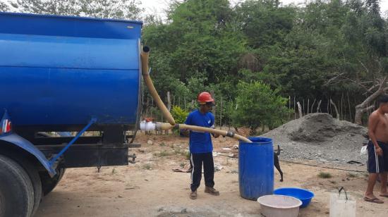 Imagen referencial. Un trabajador distribuyendo agua de un tanquero en Guayaquil, 28 de agosto de 2023. 