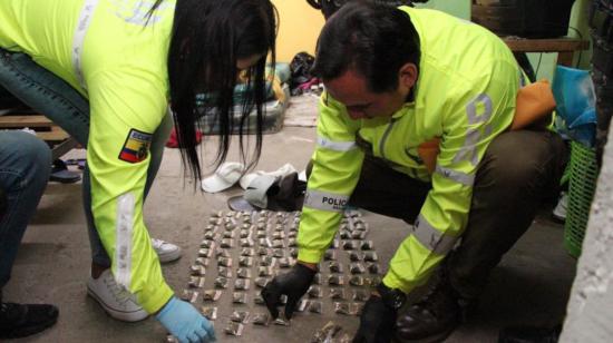 Dos policías muestran varias dosis de droga en Quito, en 2022.