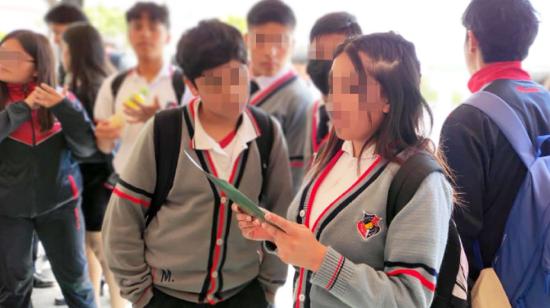 Imagen referencial de dos jóvenes leyendo el protocolo para tratar casos de violencia digital, presentado en Quito, el 28 de septiembre de 2023.