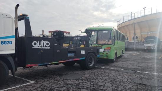 Una grúa moviliza un bus en un patio de retención vehicular de Quito, el 12 de octubre de 2023.