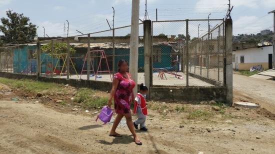 Una madre camina con su niña en la cooperativa Reinaldo Quiñonez, en Nueva Prosperina (noroeste), el distrito más afectado por violencia criminal e intrafamiliar en Guayaquil. 