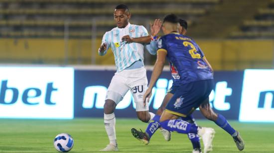 Jugadores de Universidad Católica y Delfín disputan un balón en la Fecha 10 de la LigaPro, el 23 de octubre de 2023.