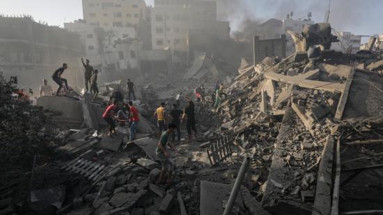 Sobrevivientes de un bombardeo en la Franja de Gaza buscan por los cuerpos de sus familiares, el 25 de octubre de 2023.