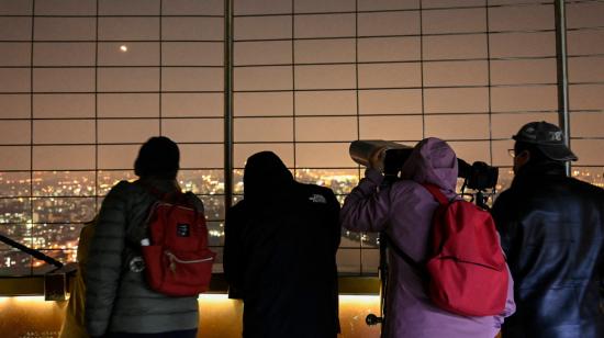 Personas en China viendo el último eclipse lunar parcial en 2022. 