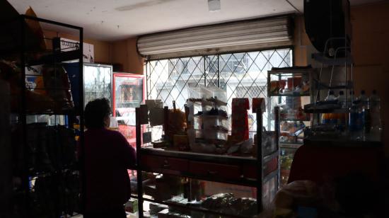 Imagen referencial. Una mujer en una tienda de barrio en Quito, durante las primeras horas de los apagones en la capital, el 27 de octubre de 2023. 