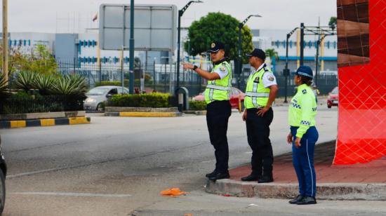 Dos oficiales de la CTE junto a una agente de la ATM en una intersección del norte de Guayaquil, el 1 de noviembre de 2023.