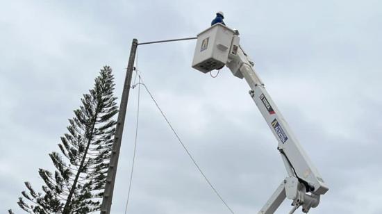 Un trabajador de CNEL EP en labores en un poste de alumbrado en Guayaquil, el 14 de noviembre de 2023.