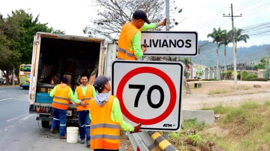 Empleados municipales colocan la nueva señalética de 70 kilómetros por hora en la vía a la Costa, norte de Guayaquil, el 16 de noviembre de 2023.