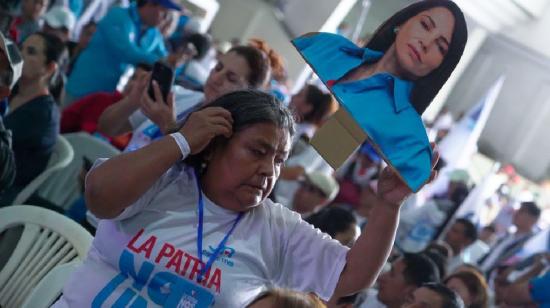 Participante de la convención de la Revolución Ciudadama sostiene una imagen de Luisa González.