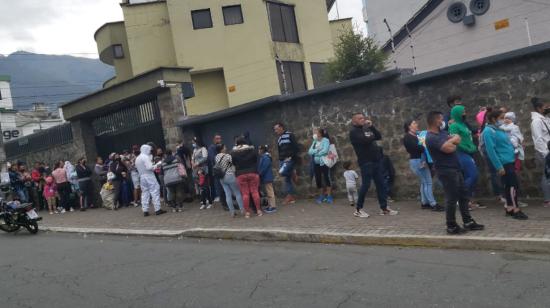 Migrantes venezolanos hacen fila en Quito en los exteriores de una fundación, en junio de 2022.