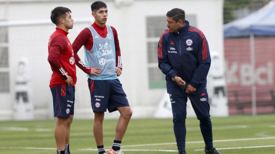 Nicolás Córdova conversa con dos futbolistas en un entrenamiento, en Santiago, el 17 de noviembre de 2023.