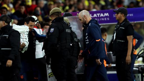 Félix Sánchez Bas sale de la cancha del estadio Rodrigo Paz Delgado con protección policial, después de la victoria de Ecuador ante Chile, por 1 a 0, el 21 de noviembre de 2023. 