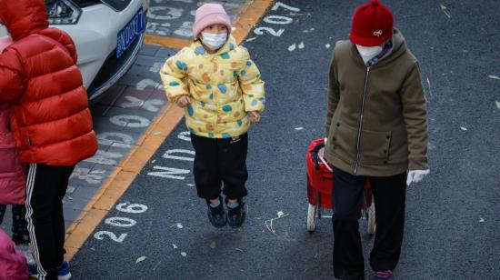 Niños con mascarillas en una calle de Beijing, China, el 23 de noviembre de 2023.
