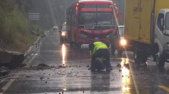 Un agente de tránsito retira las rocas que cayeron en una vía con la lluvia en Cuenca el 23 de noviembre de 2023.