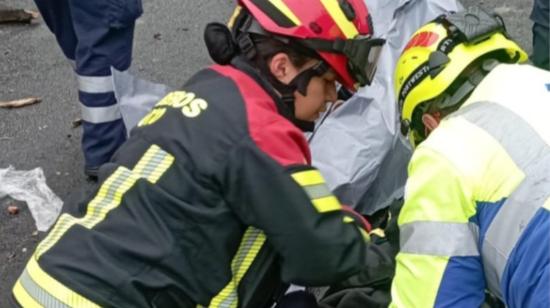 Bomberos de Quito asisten a uno de los afectados en el accidente en la vía Panamericana norte, el 24 de noviembre de 2023.