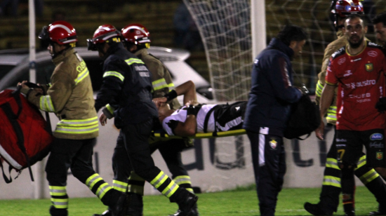 El árbitro Robert Cabrera es retirado de la cancha en camilla, en Cuenca, el 25 de noviembre de 2023.