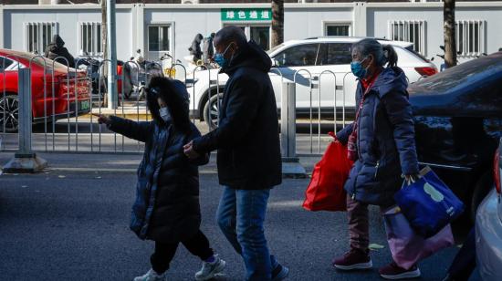 Un niño camina junto a su padre en Beijing, China, el 27 de noviembre de 2023.