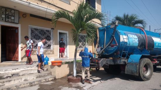 Ciudadanos en Guayaquil se abastecen de agua, durante el corte del servicio, el 25 de noviembre de 2023.