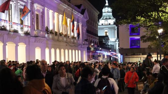 Cientos de personas caminan en el centro de Quito, durante las fiestas de fundación, en diciembre de 2023.