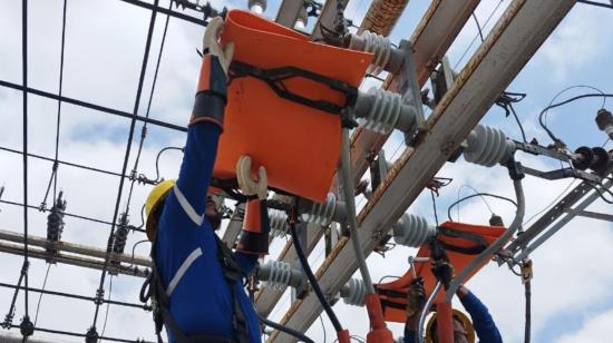 Un trabajador de CNEL realizando tareas de mantenimiento en la alimentadora de electricidad de Puerto Azul, el 11 de diciembre de 2023. 