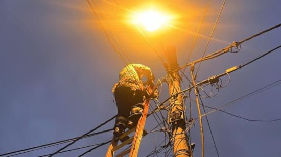 Un trabajador de CNEL EP arreglando un poste de alumbrado eléctrico en Guayaquil.