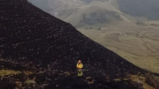 Un bombero en tareas de enfriamiento de incendio forestal en el parque nacional Cajas el 13 de diciembre de 2023.