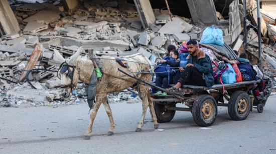 Un hombre junto a un niño abandonan un campo de refugiados en el centro de Gaza, tra una nueva orden de evacuación por bombardeos de Israel, el 22 de diciembre de 2023.