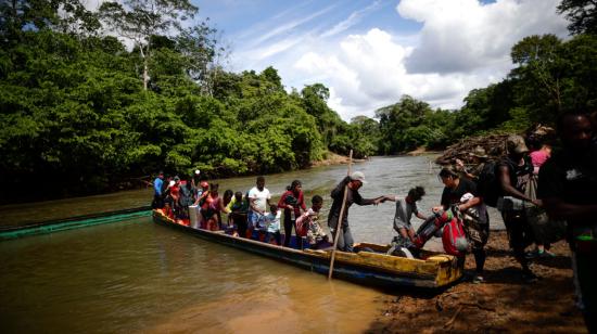 Migrantes descienden de una canoa antes de llegar a la Estación de Recepción Migratoria (ERM) de Lajas Blancas, el 18 de diciembre de 2023, luego de atravesar la selva del Darién (Panamá).