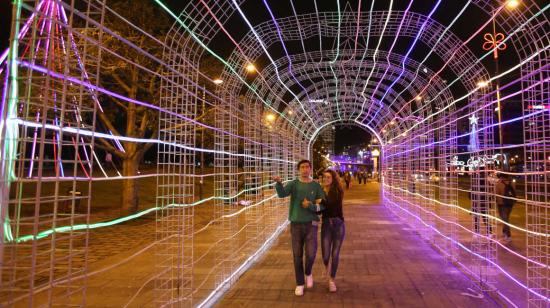 Una pareja camina por decoraciones de luces en Quito, el 19 de diciembre de 2023. 