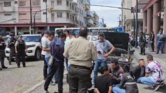 Agentes de la Policía Nacional junto a los dos detenidos en el centro de Guayaquil, el 28 de diciembre de 2023.