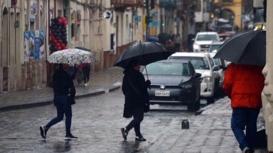 Personas caminan bajo la lluvia en el centro de Cuenca el 23 de noviembre de 2023.