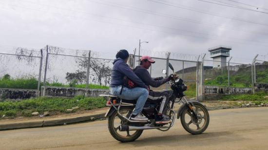 Una motocicleta circula por La Germania, barrio del norte de Guayaquil, a un lado de la cárcel Regional, desde donde alias 'Fito' se fugó.   