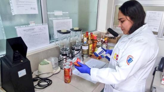 Una técnica de la Arcsa examinando un producto enlatado, en un laboratorio de Quito, el 4 de enero de 2024.