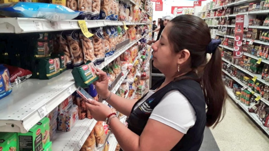 Funcionaria del Arcsa revisa alimentos procesados en la percha de un supermercado, enero de 2024. 