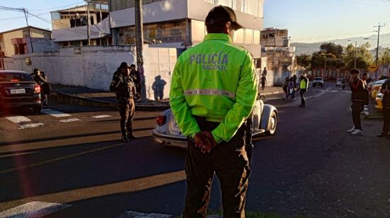 Un policía vigila el ingreso de los estudiantes en un colegio de Quito, el 24 de enero de 2024.