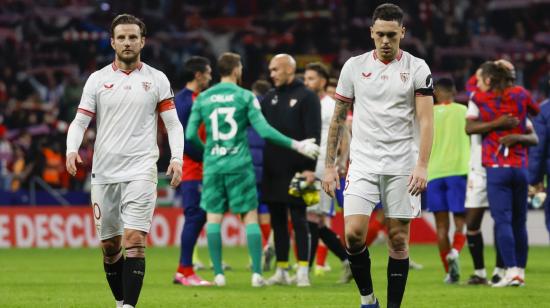 Los jugadores del Sevilla Iván Rakitic (i) y Lucas Ocampos (d) tras el partido de cuartos de final de la Copa del Rey frente al Atlético de Madrid, el 25 de enero de 2024.