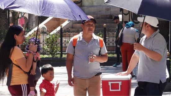 Personas utilizan sombrillas para protegerse del calor en el centro de Cuenca el 26 de enero de 2024.