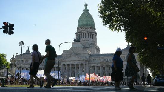 La gente cruza la calle cerca del Congreso y los partidos de izquierda protestan mientras los legisladores debaten el "proyecto de ley general" de reformas económicas del gobierno en Buenos Aires el 1 de febrero de 2024. 