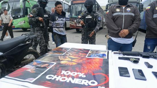 Un policía escolta a un presunto integrante de la banda Los Choneros, detenido en Guayaquil, el 7 de febrero de 2024.