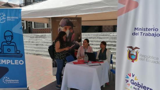 Una joven realiza consultas a funcionarios del Ministerio de Trabajo, que participan en una feria de artesanos, en Loja, en marzo de 2023. 