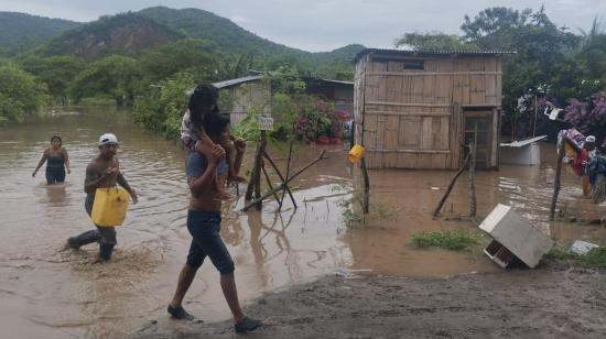 Habitantes evacúan una zona rural de Puerto López, en Manabí, afectada por las recientes lluvias, el 19 de febrero de 2024.