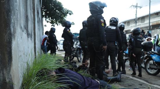 Policía tira al suelo a sospechosos durante una operativo en Pascuales, al norte de Guayaquil. 