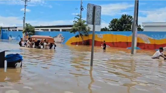 Las fuertes lluvias inundaron las calles de Chone. Una familia tuvo que cargar un ataúd entre las aguas, el 21 de febrero de 2024.