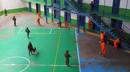 Militares vigilan a presos del CRS Cotopaxi, mientras realizan la limpieza de su pabellón, el 22 de febrero de 2024.